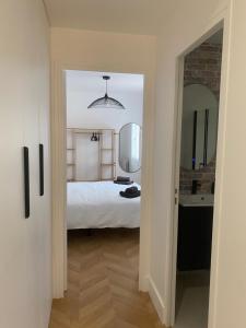 a bedroom with a bed and a mirror and a sink at La maison Eydel 2 à 4 voyageurs in Saint-Maurice +7 photos