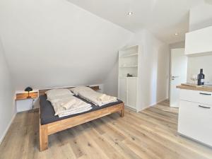 a bedroom with a bed with a wooden floor at Apartments Zur Bauerndiele " Lüttje Stuuv" in Hage