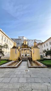 a building with a fountain in the middle of a courtyard at Vinum Apartamentos 1890 in Coimbra