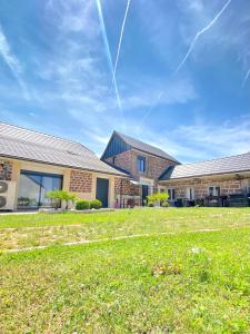 a building with a grass field in front of it at Chambres d'hôtes - La correziene in Allassac