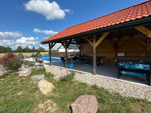a pavilion with a ping pong table and a pool at Koniec Świata dom 84m2 z balią i basenem na wyłączność in Mikołajki