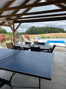 a table and chairs on a patio with a swimming pool at Koniec Świata domek z basenem in Mikołajki