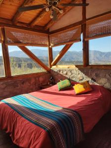 a bed in a room with a large window at Cabaña La Mostacita - Complejo El Taller in Potrerillos