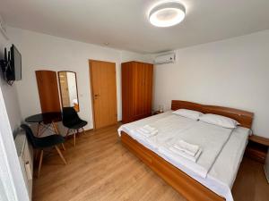 a bedroom with a bed and a table and chairs at La Casa in Sibiu
