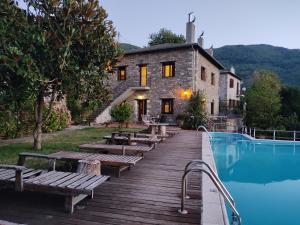 a house and a pool with benches next to a building at Miression Pelion House in Mouresi