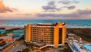 a hotel on the beach with the ocean in the background at Modern Comfort and Coastal Charm in Port Aransas