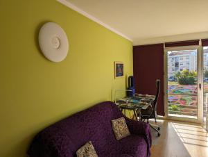 a living room with a purple couch and a table at Apartment Lisbon Airport in Lisbon