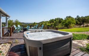 un bain à remous installé sur une terrasse en bois dans l'établissement Large patio and hot tub near wine country, à Fredericksburg
