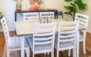 une table de salle à manger avec des chaises blanches et une table avec une peinture de cochon dans l'établissement Large patio and hot tub near wine country, à Fredericksburg 17 autres photos