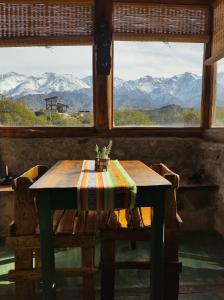 a table in a room with a view of mountains at Cabaña La Mostacita - Complejo El Taller in Potrerillos +21 photos