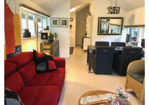 a living room with a red couch and a kitchen at Mooie recreatie woning Schipborg in Schipbork