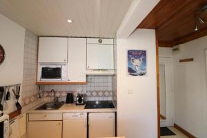 a kitchen with white cabinets and a microwave at Résidence Roches Rouges B - Appartement calme et lumineux au pied des pistes. MAE-1714 in Tignes