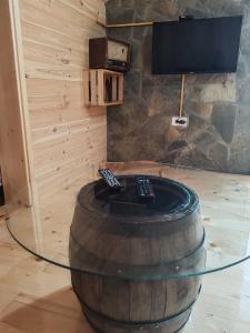 a room with a wine barrel with two remote controls at Rural household Konak Vukovica in Mojkovac