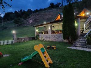 a house with a playground in the yard at night at Rural household Konak Vukovica in Mojkovac