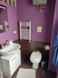 a purple bathroom with a toilet and a sink at Casa Berna in Rome