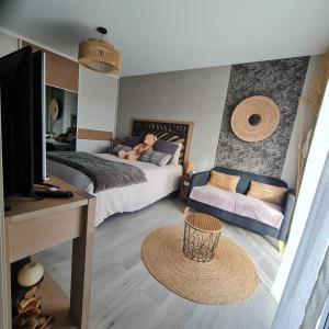 a man laying on a bed in a bedroom at Joli Appartement de plain-pied in Pornic