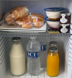 a refrigerator filled with milk and other food items at Seacrest Guest House in Weymouth