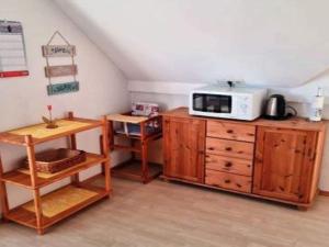 a kitchen with a microwave on top of a wooden cabinet at Ferienwohnung in Lemkenhafen for 2 Personen in Lemkenhafen auf Fehmarn +18 photos