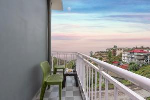 a balcony with two chairs and a table at Kasauli Star View Near Mall Road in Kasauli