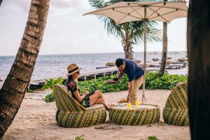 a man and woman sitting in chairs on the beach at Matachica Beach Resort and Spa in San Pedro +61 photos