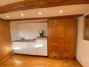 una cucina con armadietti bianchi e porta in legno di Double Room Linden Blossom a Schuttertal