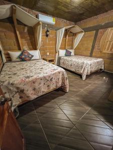 a bedroom with two beds in a brick wall at Finca las Isabeles in Xochitepec