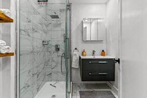 a bathroom with a shower and a sink at Appartement haut de gamme NDG in Montreal +6 photos