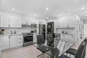 a kitchen with a glass table and white cabinets at Appartement haut de gamme NDG in Montreal
