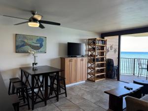 Sala de estar con mesa de comedor y TV en Luxury Oceanfront Turtles Sunsets - indigomaui -, en Kahana