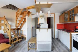 a small kitchen with a staircase in a tiny house at Résidence Le Bastion I - Appartement en duplex spacieux MAE-4204 in La Plagne Tarentaise
