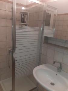 Un baño blanco con lavabo y ducha. en Villa Thea, en Sísion 4 fotos más