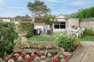 a garden with flowers and a table and chairs at 5 min château Charmante maison et son jardin privé in Versailles
