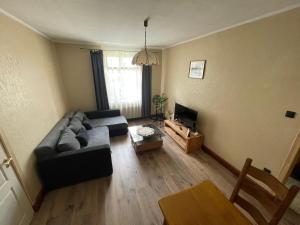 a living room with a couch and a tv at Katrīnas apartamenti in Kuldīga