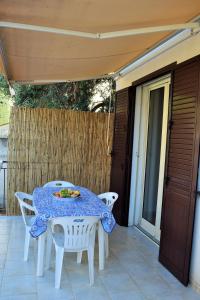 un tavolo bianco e sedie su un patio di Villa Rosi a Isola delle Femmine