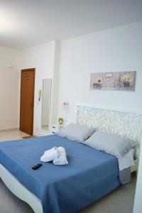 una camera con un letto blu e un asciugamano sopra di Villa Rosi a Isola delle Femmine
