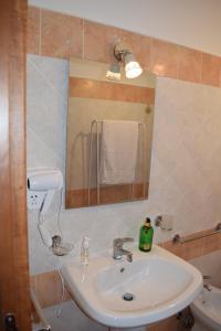un bagno con lavandino e specchio di Villa Rosi a Isola delle Femmine Altre 28 foto
