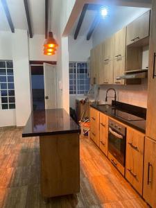 a kitchen with wooden cabinets and a black counter top at Hermosa cabaña en Guarne in Copacabana