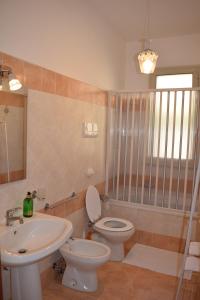 un bagno con un water bianco e un lavandino di Villa Rosi a Isola delle Femmine