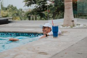 a man in a swimming pool with a drink at La Cascada Hotel Boutique in Juanacatlán +15 photos