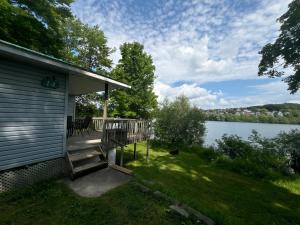 un porche de una casa junto a un lago en Camping Chalets Lac St-Augustin, en Quebec