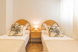 two twin beds in a room with a night stand at Apartamento Boho en El Soho de Málaga in Málaga