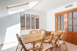 a dining room with a wooden table and chairs at Apartamento Boho en El Soho de Málaga in Málaga