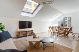a living room with a couch and a tv and a table at Apartamento Boho en El Soho de Málaga in Málaga