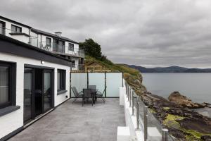 a balcony of a house with a view of the water at Pierside Apartments Deluxe Accommodation in Portsalon