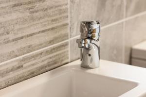 a bathroom sink with a silver faucet on it at Pierside Apartments Deluxe Accommodation in Portsalon +37 photos