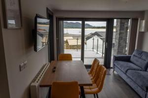 a living room with a table and a couch at Pierside Apartments Deluxe Accommodation in Portsalon