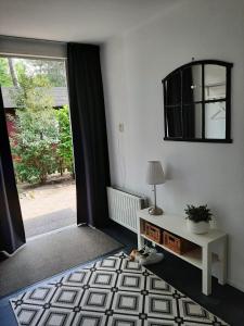 a living room with a window and a table with a lamp at Luxe 5 pers chalet natuurlijk gelegen in IJhorst