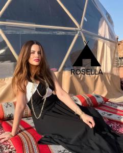 a woman sitting on a bed in a tent at ROSELLA Wadi Rum in Disah