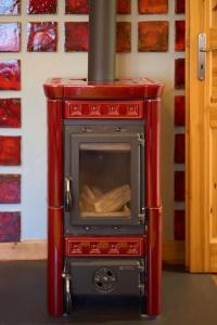 a red woodburning stove with a stove at Familiennest am MüritzSee mit Kamin & Sauna in Sietow Dorf