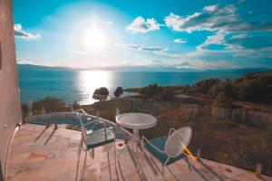 a balcony with a table and chairs and the ocean at Villa Bella Luxury Ohrid in Ohrid